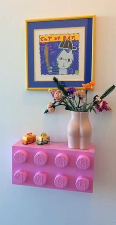 a vase with flowers and legos on a shelf