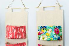 two wall hangings made out of fabric with flowers and leaves on them, one has a pocket for sewing material