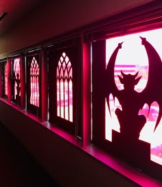 the silhouettes of windows are lit up with red light and shadows on them,