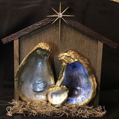 a nativity scene with three blue agatel pieces in a wooden box on black fabric