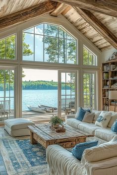 a living room filled with furniture next to a large window covered in lots of windows