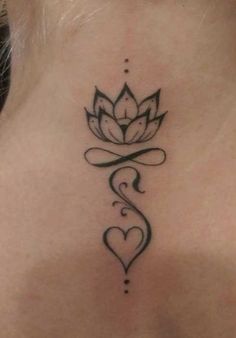 the back of a woman's neck with a lotus tattoo on her left side