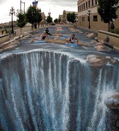 two people standing in front of a waterfall painted on the ground with blue paint and water