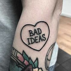 a man's arm with a heart shaped tattoo that says bad ideas on it