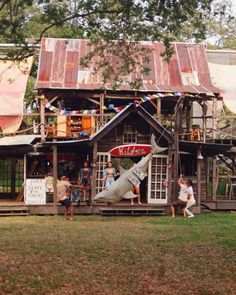 people are sitting on the porch of a house with a rocket in front of it