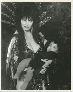 a woman holding a child in her arms and posing for a photo with another person