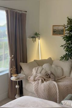 a living room filled with furniture and a plant in the corner on top of a window sill