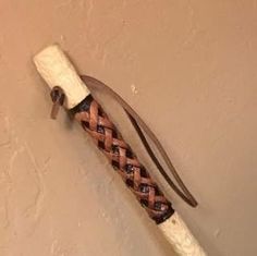 a knife with braided handle hanging on the wall