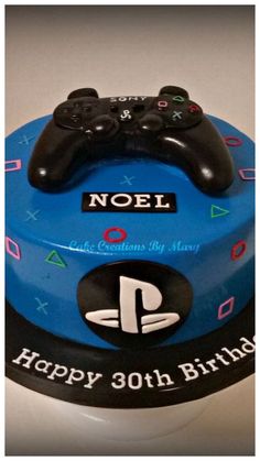 a blue birthday cake with a video game controller on it's top and name