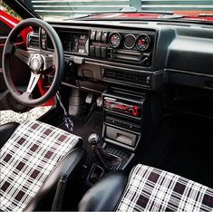 the interior of a car with plaid seats and steering wheel covers on it's dashboard