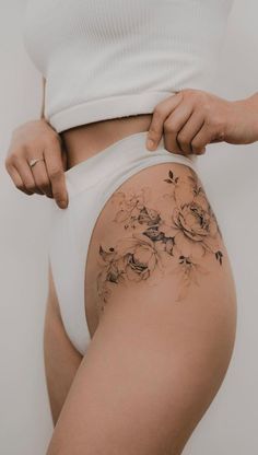 a woman is showing off her thigh with flowers on it