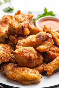 chicken wings on a plate with dipping sauce