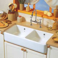 two white sinks in a kitchen under a window