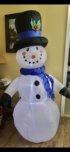 a large inflatable snowman with a top hat and scarf