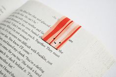 an open book with a piece of paper sticking out of it's middle page