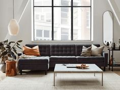 a living room with a couch, coffee table and large window in the center area