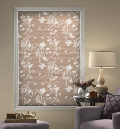 a living room with a couch, chair and window covered in sheer blinds that have white flowers on them