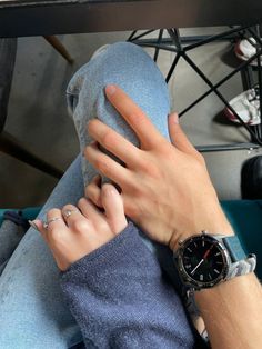 a person with their hand on the leg of another persons arm and wearing a watch