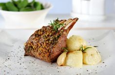 a piece of meat and potatoes on a white plate with garnishes around it