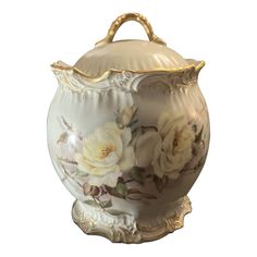 a white and gold vase with flowers on the bottom is sitting in front of a white background