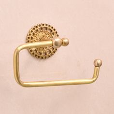 an antique brass toilet paper holder on a white wall