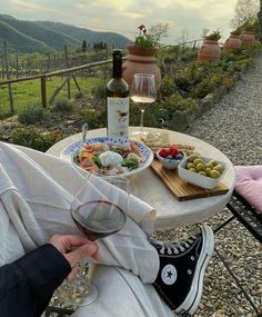 a person sitting at a table with food and wine