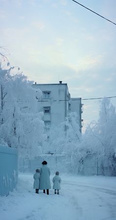 two people walking down a snow covered street