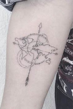 a woman's arm with a small arrow and map tattoo on the left forearm