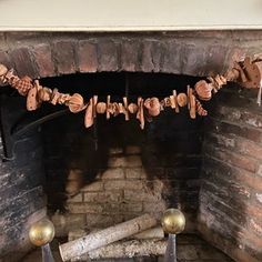 a fire place with logs on the mantle and some decorations hanging from it's sides