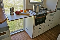 a small kitchen with an oven, sink and stove in the corner next to a window