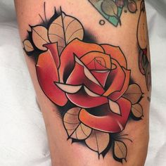 a close up of a rose tattoo on a person's leg