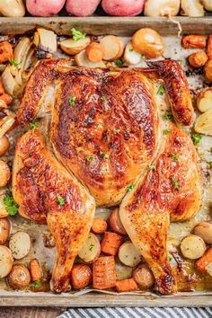 a roasting pan filled with chicken, potatoes and carrots