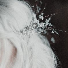 a woman with white hair wearing a flower crown