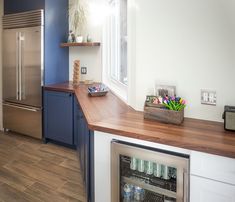 a kitchen with blue cabinets and wooden counter tops