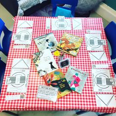 a red and white checkered table topped with lots of paper cut out to look like children's books