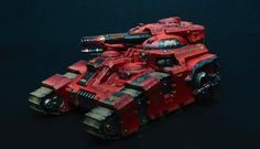 a red painted warhammer tank on a black background