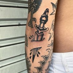 a man's arm with tattoos on it and an image of a person holding a knife