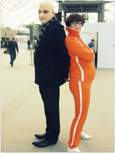 two people dressed in orange and black standing next to each other