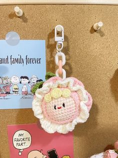 there is a key chain attached to a bulletin board with pictures and magnets on it