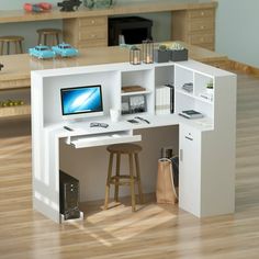 a desk with a computer on top of it in the middle of a living room