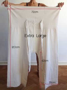 a woman is holding up a white sheet with measurements on it and the length chart below her