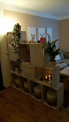 a living room filled with lots of furniture next to a wooden floor covered in potted plants