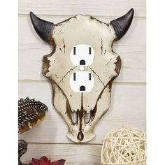 a cow's skull is mounted to the wall with two outlet plates on it