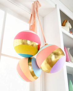 three colorful ornaments hanging from a window sill