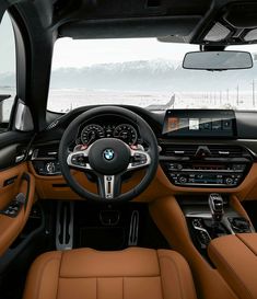 the interior of a bmw car with tan leather seats and steering wheel, dashboard, dash board, and touch screen