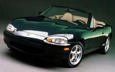 a green sports car with the top down