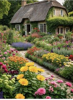 a garden filled with lots of flowers next to a house