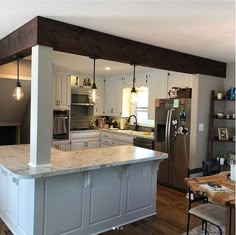 a kitchen with an island in the middle of it and lots of lights hanging from the ceiling