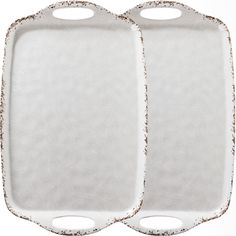 two white ceramic serving trays with handles on each side, one is empty and the other has gold speckles