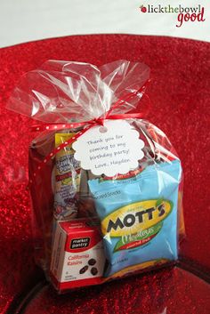 a bag filled with lots of food on top of a red countertop next to a sign